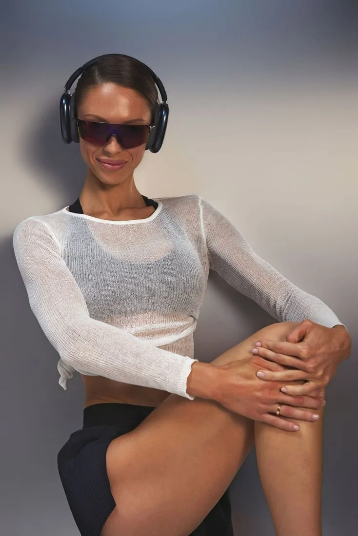 Jules smiling in a sheer white knit top